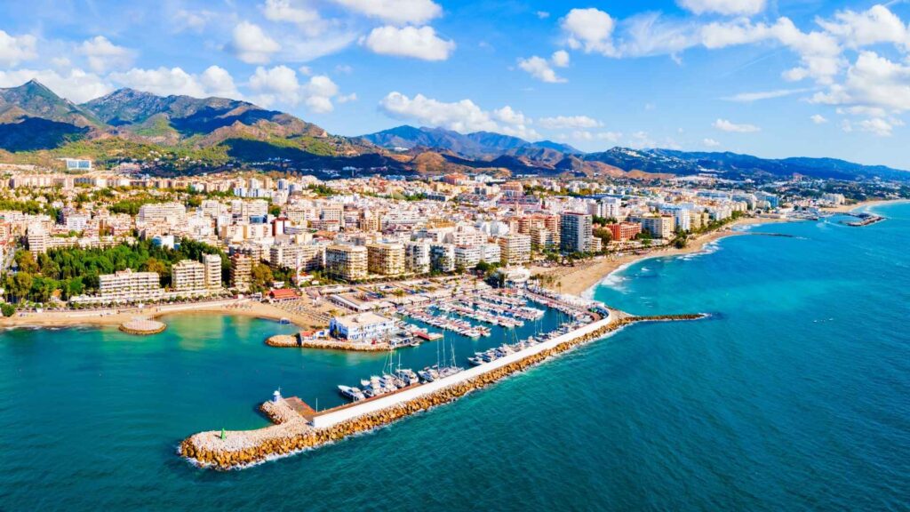 Aerial view of a coastal city in southern Spain showing beaches, marina, and modern apartments along the Costa del Sol, illustrating key Trends in Southern Spain.