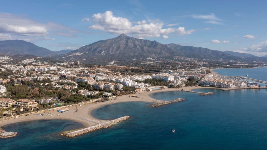 Aerial view of Nueva Andalucia and Marbella coastline, Spain, showing luxury homes and Mediterranean beaches, highlighting the differences in lifestyle and property appeal in Nueva Andalucia vs Marbella.