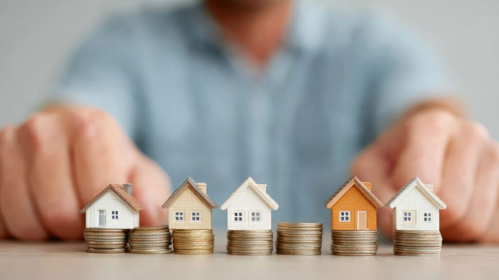 Miniature houses on stacked coins representing rental yields and property investment returns in Nueva Andalucía, Marbella