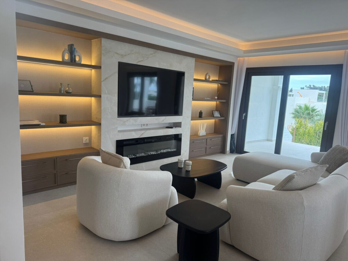 Modern living room with built-in TV wall and terrace access in luxury property in Marbella