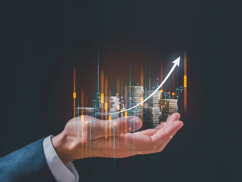 Concept of real estate investment growth in southern Spain, with stacked coins and upward arrow symbolizing increasing property value.
