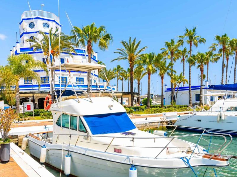 Luxury yachts moored in Estepona marina on a sunny day, showcasing the coastal lifestyle of the most exclusive neighborhoods in Estepona.