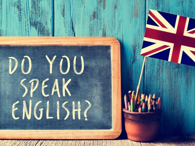 Chalkboard with the text ‘Do you speak English?’ next to a pot of pencils and a small Union Jack flag.