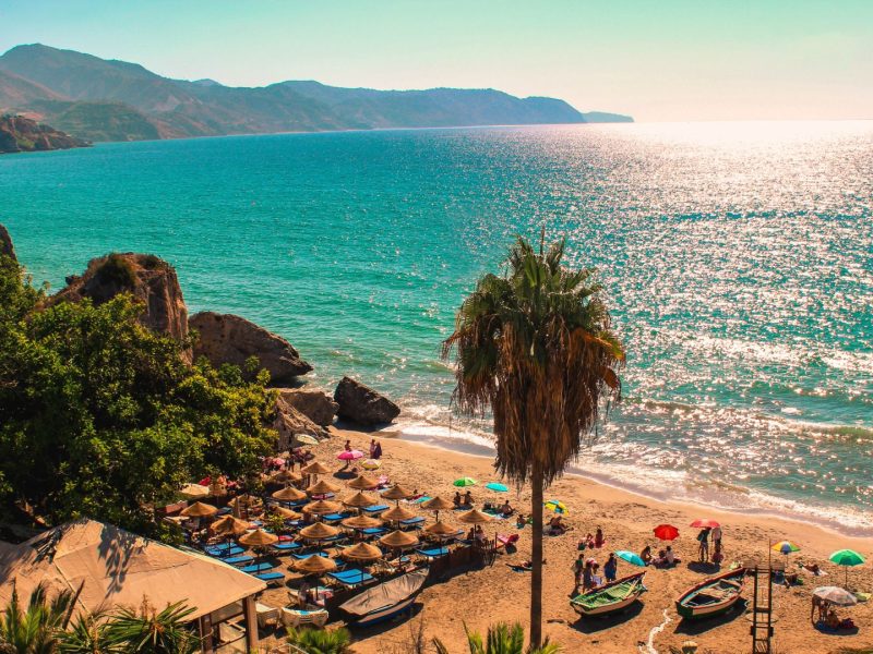 Beautiful beach on the Costa del Sol in Spain with turquoise sea and sun umbrellas, ideal for property investment.